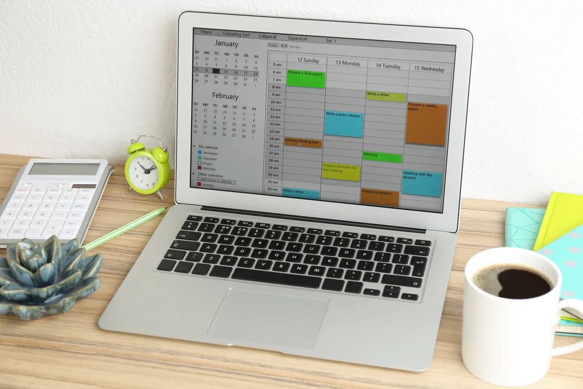 A laptop displaying a booking calendar dashboard in an office